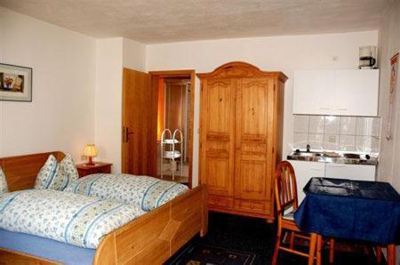 Schlafzimmer mit einem Bett und einem Holzschrank in der Unterkunft Haus Stefanie in Inzell