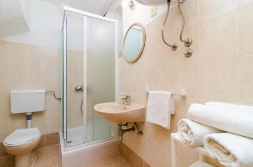 a bathroom with a toilet sink and a shower at Apartments Peppino - Old Town in Dubrovnik