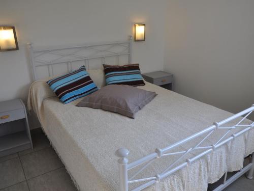 Una cama con dos almohadas encima en un dormitorio. en Holiday Home in Moriani-Plage near Beach, en San-Nicolao