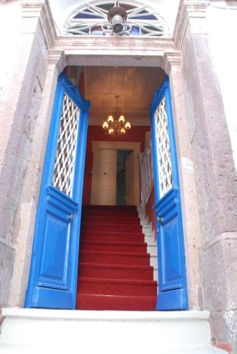 a stairway with blue doors and red stairs at Cunda Adali Pansiyon in Ayvalık