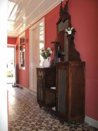 a room with a dresser with a mirror and red walls at Cunda Adali Pansiyon in Ayvalık