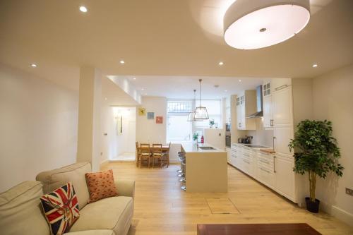 een woonkamer en een keuken met een bank en een tafel bij Luxury 2 bed/bath apartment next to Hyde Park in Londen