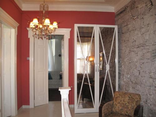 a living room with red walls and a chandelier at Cunda Adali Pansiyon in Ayvalık