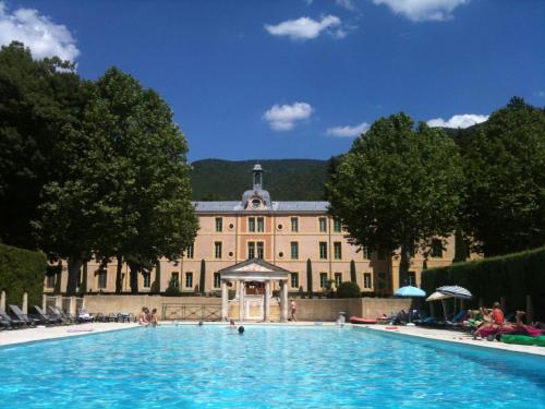 a large swimming pool in front of a building at Historical castle in Montbrun les Bains with pool in Montbrun-les-Bains