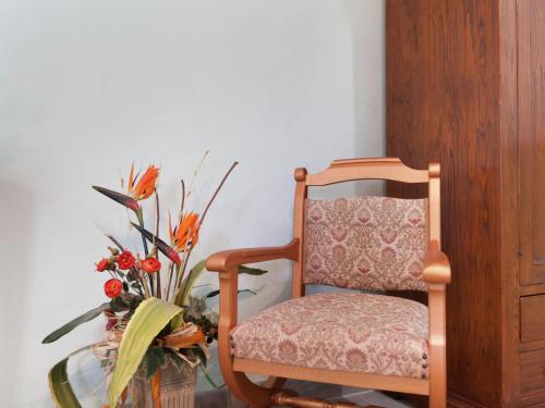 a chair and a glass table with a vase of flowers at Farmhouse in Apecchio with Pool & Spa in Apecchio