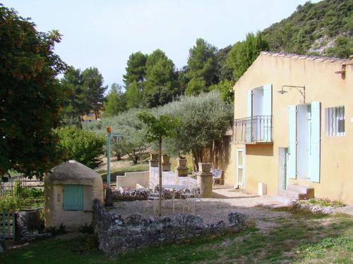 a house with a stone wall next to a building at Lovely Holiday Home in Saint Saturnin l s Apt with Pool in Saint-Saturnin-lès-Apt