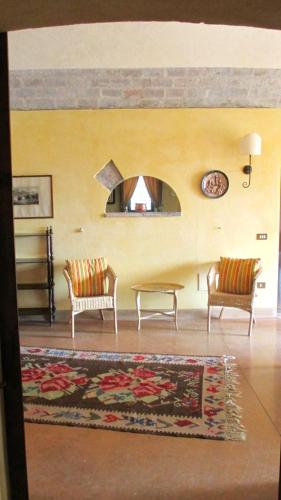 a living room with two chairs and a table at Agriturismo Le Colombaie in Busseto
