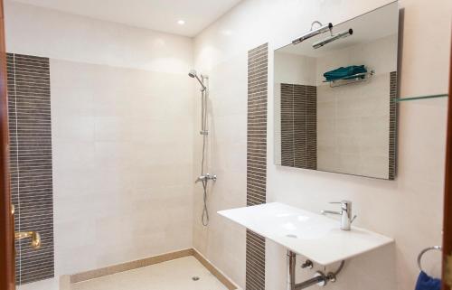 ein Bad mit einem Waschbecken und einer Dusche in der Unterkunft Villa Mela in Playa Honda