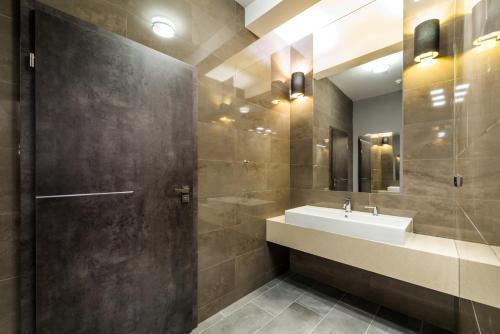 ein Bad mit einem Waschbecken und einem Spiegel in der Unterkunft Hotel Wodnik in Giżycko