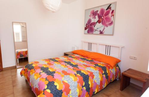 1 dormitorio con 1 cama con un edredón colorido en Villa Mela, en Playa Honda