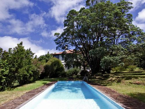 una piscina blu nel cortile di una casa di Quinta Das Colmeias Cottage a Santo da Serra