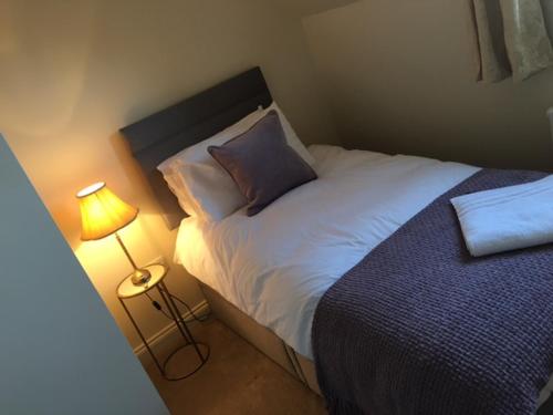 a small bedroom with a bed and a lamp at Scalby Grove Cottage in Scalby