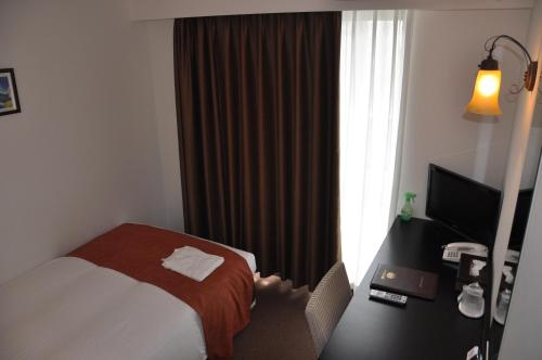 a hotel room with a bed and a window at Hotel Noah in Ginowan
