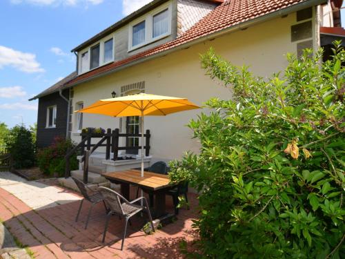 tavolo e sedie con ombrellone davanti casa di Holiday home in Stormbruch with terrace a Stormbruch