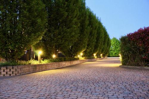 a cobblestone street with a row of trees at night at Hotel Air Bag in Lodi