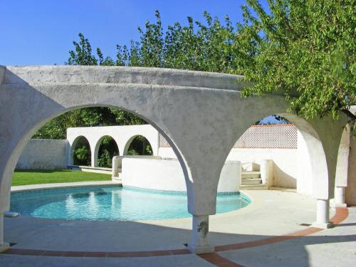 a stone bridge over a swimming pool in a yard at Holiday home with private pool in Villedaigne