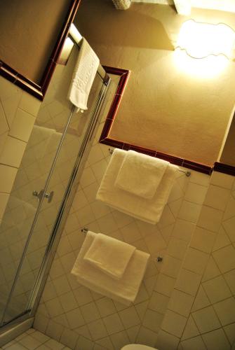 a bathroom with white towels hanging on a shower at Appartamento il Battistero in Pistoia