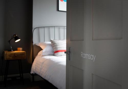 a bedroom with a white bed and a door at The Duke William in Canterbury