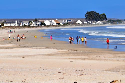 a group of people walking on a beach at 3 Dolphins in Britannia Bay