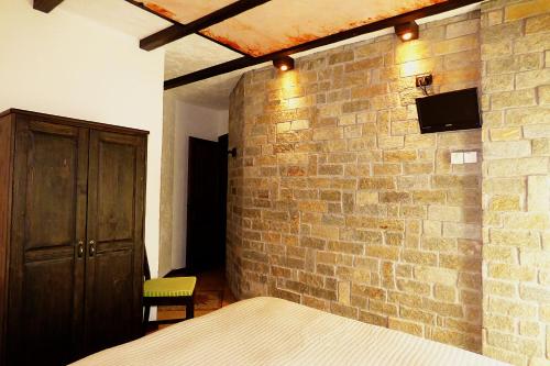 a bedroom with a brick wall and a bed at Chalet Sul Lago Hotel In Montagna in Moncenisio