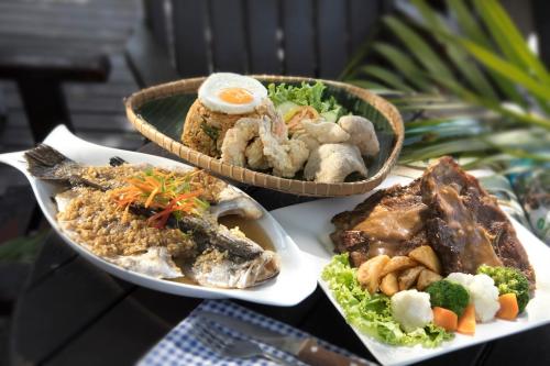 una mesa con tres platos de comida. en Perhentian Island Resort en Perhentian Island
