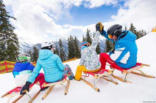 a group of people sitting on skis in the snow at Ferienwohnen Mattle MIT IM RUCKSACK die SILVRETTA CARD PREMIUM in Kappl