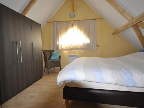 a bedroom with a bed and a window and a chair at Well-kept, detached holiday home with air conditioning in Lacapelle-Marival