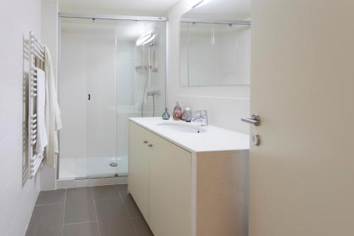 y baño blanco con lavabo y ducha. en Bravissimo Cort Reial-2A, en Girona