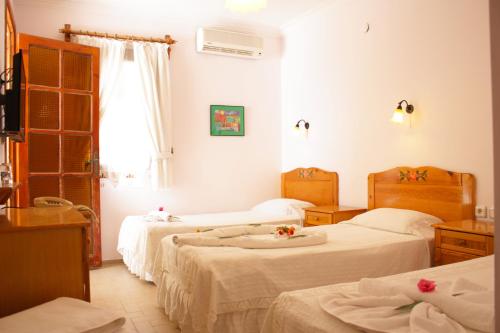 a bedroom with two beds and a window at Toloman Hotel Bitez Beach in Bitez