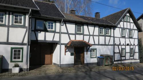 ein altes weißes und schwarzes Gebäude mit einer Tür in der Unterkunft Meisenhof in Schalkenbach
