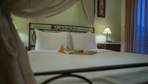 a bedroom with a bed with a tray of food on it at Evzin Hotel in Kato Loutraki