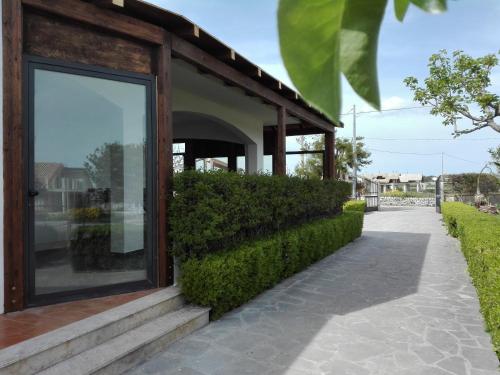 a building with a large glass window next to a sidewalk at Villa Rosa in Modica