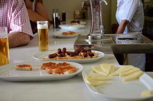 a table with plates of food and glasses of beer at Hotel Rural Casas de Don Adame in El Viso