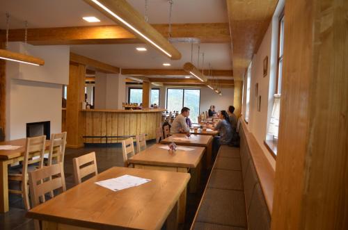 a restaurant with wooden tables and people sitting at them at Hotel Kristian in Kubova Huť