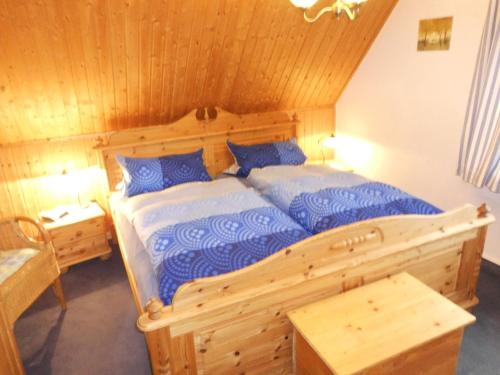 a bedroom with a wooden bed with blue pillows at Apartment in Langewiese Sauerland with garden in Winterberg