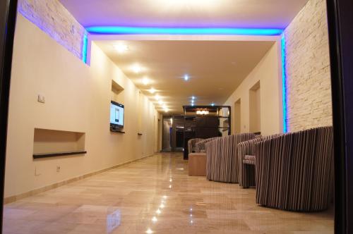 a long hallway with chairs and a blue light at Pensiunea JOJO in Băile Herculane