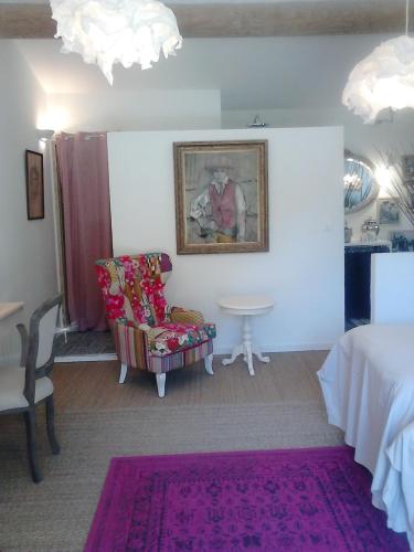 a room with a bed and a chair and a table at La Maison de Charlie in Vaugines