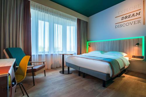 a bedroom with a bed and a sign that reads dream discover at Park Inn By Radisson Brussels Airport in Diegem