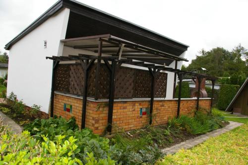 a house with a black roof and a brick wall at Ferienhaus Krüger in Loissin