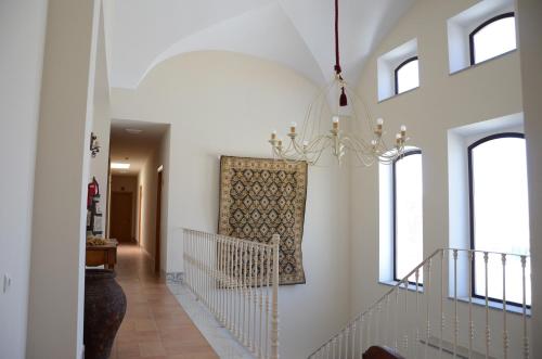 a hallway with white walls and a chandelier at Hotel Rural Casas de Don Adame in El Viso