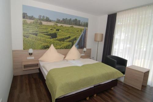 a bedroom with a bed and a view of a vineyard at Ringhotel Alfsee Piazza in Rieste