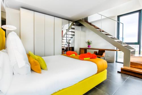 una camera da letto con un letto bianco con cuscini gialli e arancioni di Cosmo Apartments Sants a Barcellona