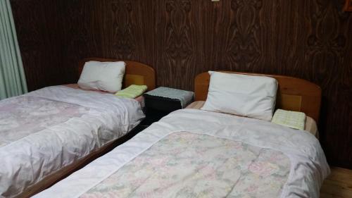 two beds sitting next to each other in a room at Minshuku Toshi in Yakushima