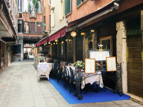 ein Restaurant mit Tischen und Stühlen auf einer Straße in der Unterkunft Belvilla by OYO Paradiso in Venedig