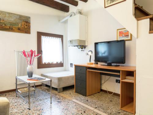 ein Wohnzimmer mit einem TV auf einem Schreibtisch in der Unterkunft Belvilla by OYO Paradiso in Venedig