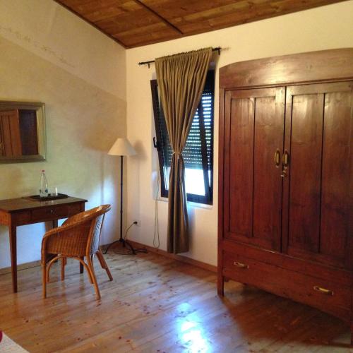 a room with a wooden cabinet and a table and a desk at Agriturismo Viridarium in Castellucchio