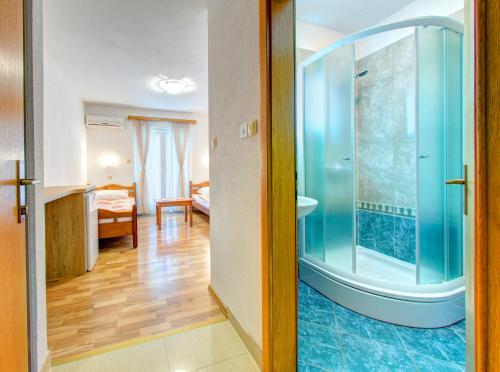 a bathroom with a shower and a bedroom at Pansion Glory in Međugorje
