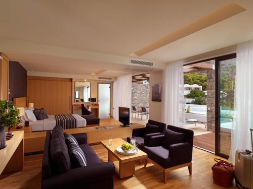 a living room with a couch and a bed at Wyndham Loutraki Poseidon Resort in Loutraki