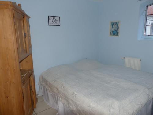 Un dormitorio con una cama y un armario de madera. en Kristiansminde Farm Holiday, en Tistrup