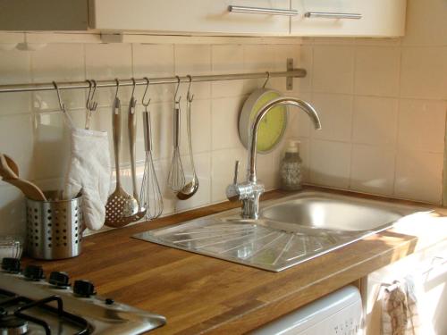 a kitchen counter with a sink and a stove at L'Annexe Apparthôtel du 8, 3 étoiles in Besançon